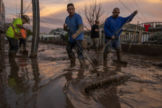 Residents work to push back wet mud that trapped cars and invaded some houses on Jan. 11, 2023 in Piru, east of Fillmore, California. A series of powerful storms pounded California in striking contrast to the past three years of severe to extreme drought experienced by most of the state. Credit: David McNew/Getty Images