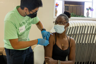 An Emory University student collects a blood sample from Carnetta Jones, right, at Cosmopolitan AME Church on Atlanta's west side on July 30, 2022. The university is studying the community's exposure to lead and other contaminants after high levels of lead were found in the soil of two historically Black neighborhoods. Credit: Lynsey Weatherspoon/Deep Indigo Collective for Inside Climate News