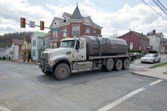 A waste water tank truck passes on the main street of Waynesburg, Pennsylvania. Credit: Mladen Antonov/AFP via Getty Images.