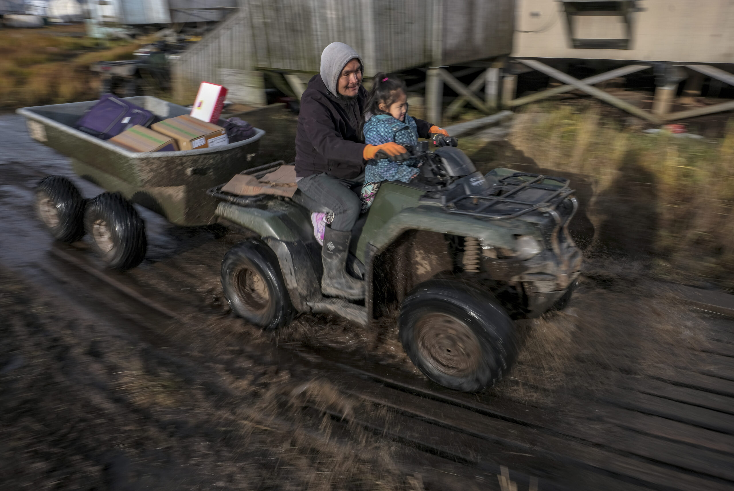 Pauly Andy transports people and belonging using an all-terrain vehicles in Newtok, Alaska, where melting permafrost, sinking tundra and flooding disturbed the boardwalks on October 9, 2019. Credit: Bonnie Jo Mount/The Washington Post via Getty Images