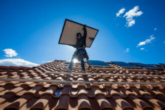 Employees of Sunrun, nation's largest rooftop solar installer, carry panels into position in North Las Vegas, Nevada.