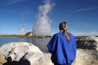 Lou Ann Varley looks out across the pond that holds water for the cooling towers at the Jim Bridger coal plant, where she worked for 37 years before retiring in 2020. Credit: Nicholas Kusnetz