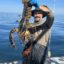 Some large lobsters are still around. Josiah Mayo stands on board Mike Packard’s F/V J&J with a nine-pound lobster in a photo taken two weeks ago. Credit: Mike Packard/Provincetown Independent.