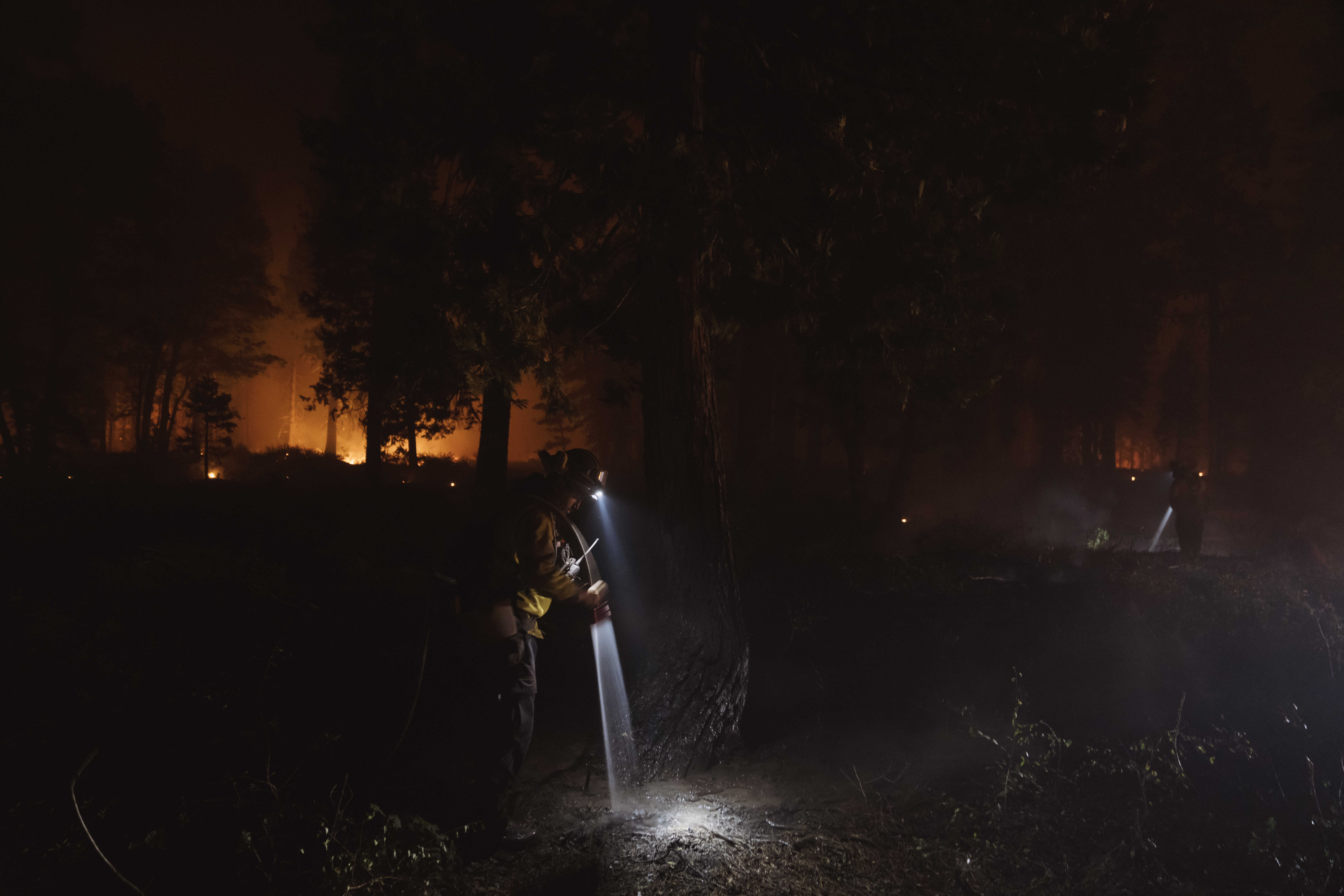 Firefighters spray down hot spots during the Mosquito Fire on Sept. 14, 2022 in Foresthill, California. Credit: Eric Thayer/Getty Images