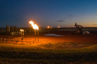 Flares light up the landscape after sunset on an oil patch in the Fort Berthold Indian Reservation on Oct. 27, 2021. North Dakota’s 2014 gas capture plan attempted to reduce flaring in the state, including on tribal land. Credit: Isaac Stone Simonelli/Howard Center for Investigative Journalism