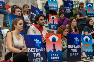 Activists in Lisbon pose holding signs during a rally against maritime mining at Luis de Camoes square. The protest against deep sea mining is an initiative of Portuguese environmental non-governmental organizations as a preview to the World Ocean Day, under the slogan "Join us to give voice to the deep sea," which denounces the use of heavy machinery that destroys marine ecosystems. Credit: Jorge Castellanos/SOPA Images/LightRocket via Getty Images.