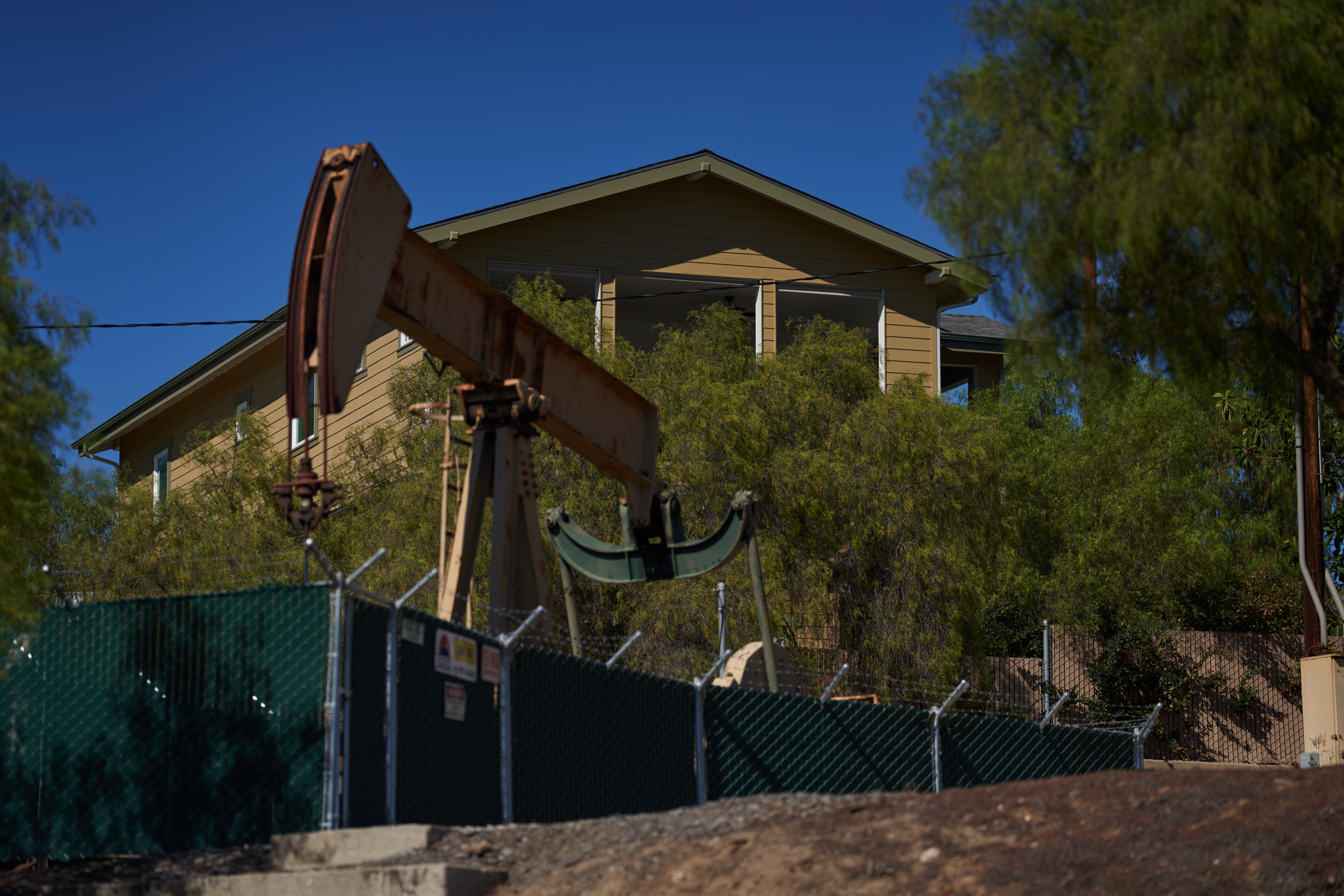 An active oil drilling rig is located next to a single family home on Sept. 21, 2022 in Signal Hill, California. Credit: Allison Dinner/Getty Images