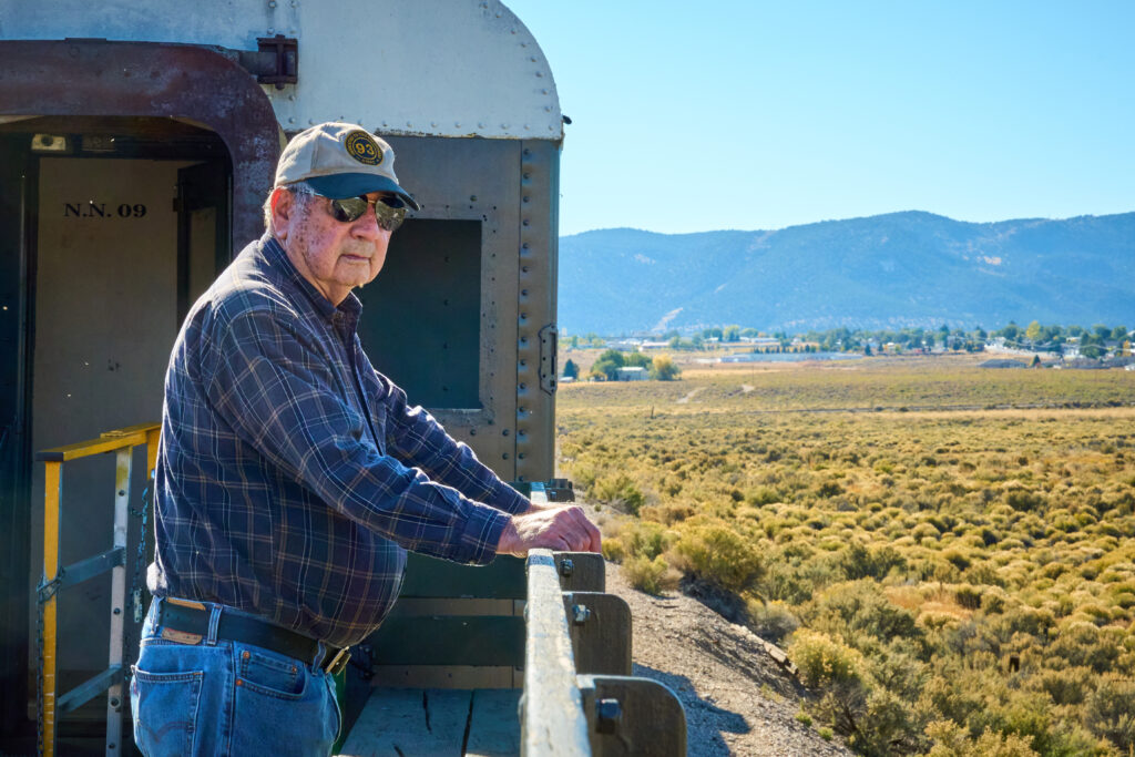 Roger Bowers looks out over the side of the train while heading back to the Nevada Northern Railway Museum in Ely, Nevada, on Thursday Oct. 5, 2023. Credit: Alex Gould