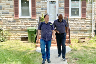 Brad Rogers, left, and Rev. Richard Partlow, the interim executive director of Cherry Hill Development Corporation, one of the community partners of the South Baltimore Gateway Partnership, on their way to a meeting at the Cherry Hill Strong's office nearby. Credit: Aman Azhar / Inside Climate News